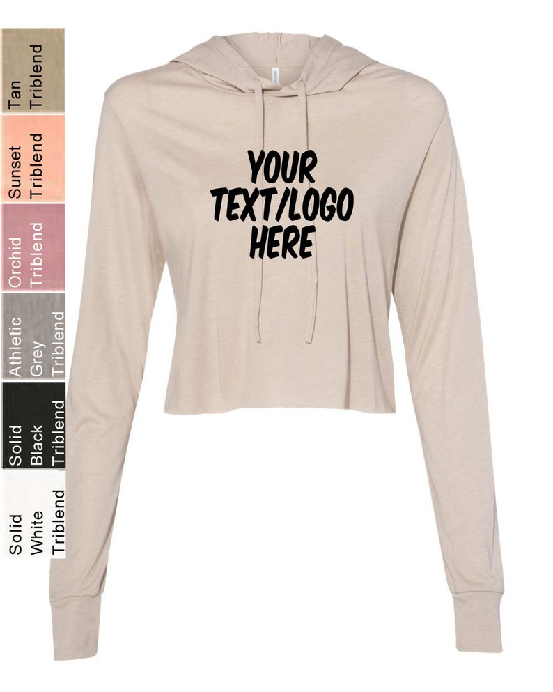 K&ouml;nnte beinhalten: Ein beiger, lang&auml;rmliger, kurzer Hoodie mit einer Kapuze mit Kordelzug. Der Hoodie hat den Text "YOUR TEXT/LOGO HERE" in Schwarz auf der Vorderseite aufgedruckt.