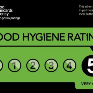 May include: A green and black Food Standards Agency sign displaying a Food Hygiene Rating of 5. The graphic features the text Food Hygiene Rating, a row of numbers from 0 to 5 with the number 5 highlighted in a black circle, and the text Very Good.