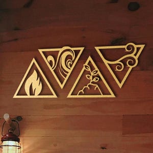 May include: Four wooden wall decor pieces in the shape of triangles, each with a different symbol representing the elements: fire, water, air, and earth. The symbols are cut out of the wood and painted gold. The decor is mounted on a wooden wall.