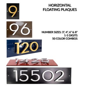 May include: A collection of horizontal floating plaques with numbers. The plaques are in various colors, including black, brown, blue, and red. The numbers are in gold, silver, and white. The text states "Number Sizes: 3", 4", 6" & 8" 1-5 Digits 50 Color Combos."