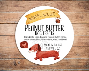May include: A round label with the text "PEANUT BUTTER DOG TREATS" and a watercolor illustration of a dachshund. The label includes the ingredients and the text "MADE IN THE USA NET WT 8 OZ."