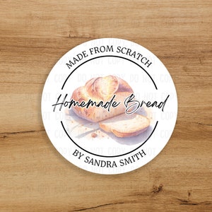 May include: A round sticker with a watercolor illustration of a loaf of homemade bread and a slice. The text reads "MADE FROM SCRATCH" and "Homemade Bread" with "BY SANDRA SMITH" at the bottom.