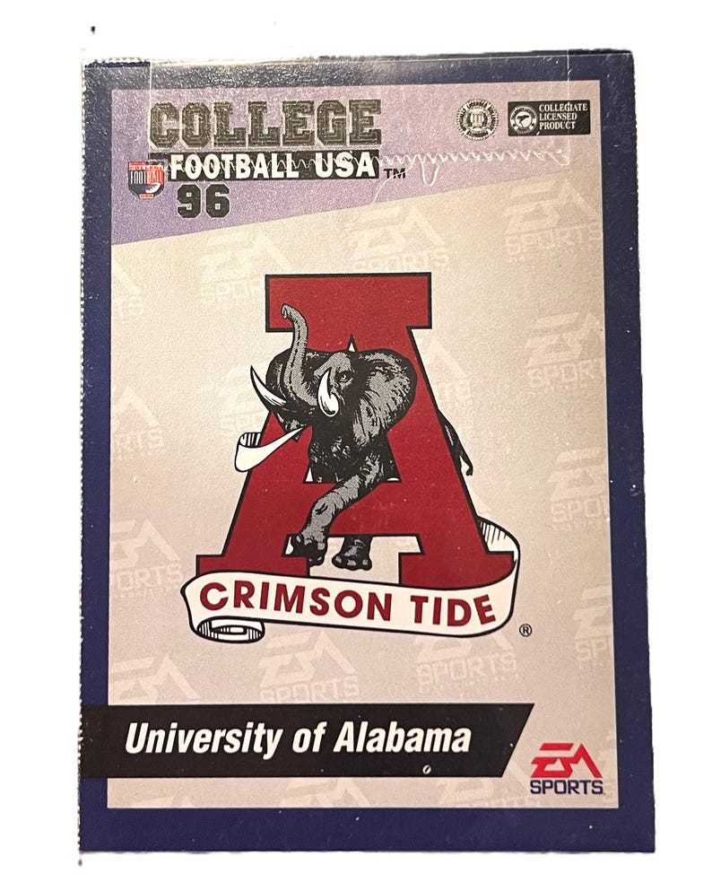 May include: A collectible trading card featuring the University of Alabama Crimson Tide. The card has a red 'A' with an elephant graphic, the words "CRIMSON TIDE" on a banner, and "University of Alabama" at the bottom. The card is from the "COLLEGE FOOTBALL USA 96" series.