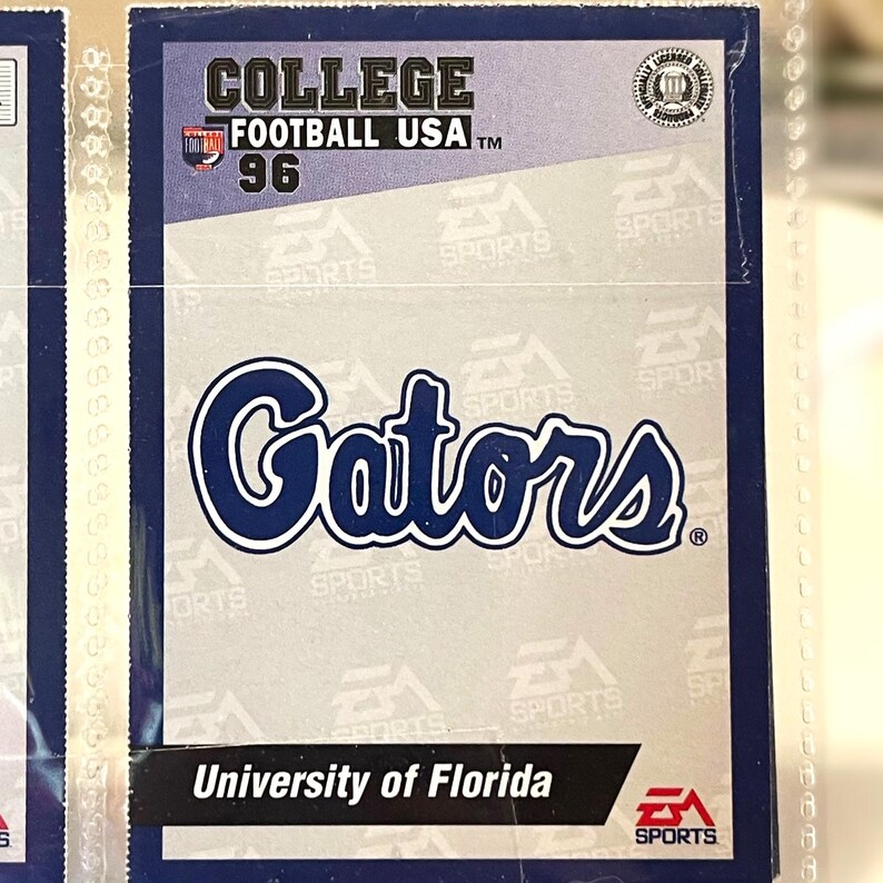 May include: A trading card featuring the University of Florida Gators. The card has the text "COLLEGE FOOTBALL USA 96" at the top. The word "Gators" is in a large, stylized font. The bottom of the card reads "University of Florida".