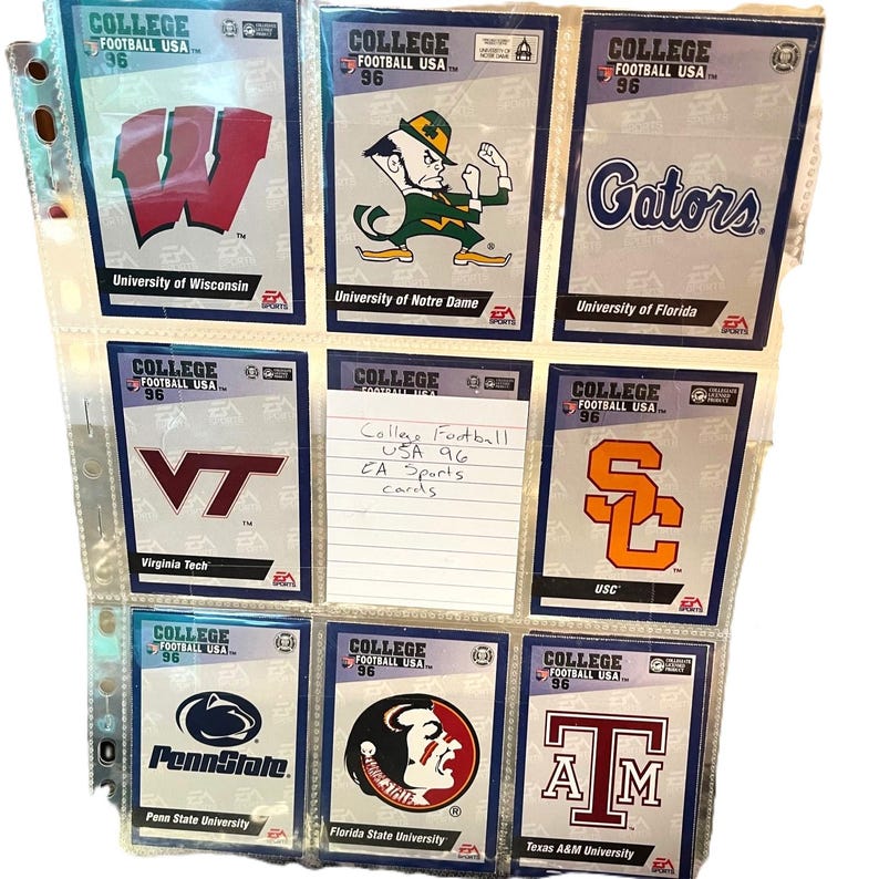May include: A collection of College Football USA '96 trading cards in a binder. The cards feature team logos and mascots from various universities, including Wisconsin, Notre Dame, Florida, Virginia Tech, USC, Penn State, Florida State, and Texas A&M.