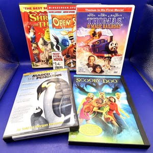 May include: A collection of five DVD movies, including "Shrek the Third", "Open Season", "Thomas and the Magic Railroad", "March of the Penguins", and "Scooby-Doo". The DVDs are in their original cases and feature colorful cover art.