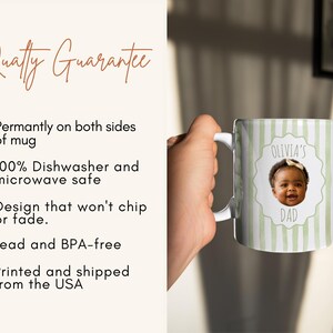 Op de afbeelding: Witte keramische mok met een handvat, met een groen-wit gestreept patroon. De mok heeft een foto van een baby met de tekst "Olivia's Dad" in een decoratief kader. De mok is aan beide zijden bedrukt en is vaatwasser- en magnetronbestendig.