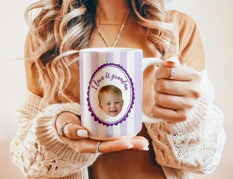 Op de afbeelding: Witte keramische mok met een paars en wit gestreept ontwerp. De mok heeft een paarse ovaal met de tekst "I love U grandma" en een foto van een baby. De mok heeft een wit handvat.