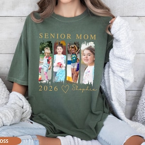 May include: A moss green t-shirt with the words "SENIOR MOM 2026" in gold lettering. The shirt features a collage of four photos of children. Below the photos is a gold heart and the name "Shopie" in script.