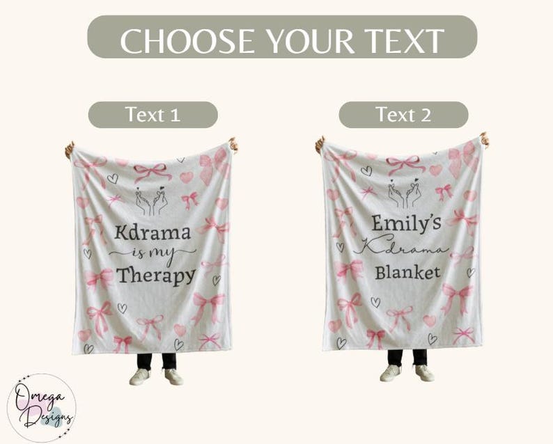 May include: A white blanket with pink bows, hearts, and the text "Kdrama is my Therapy". The blanket also features a hand gesture and is held up by a person. The blanket is a soft, cozy item.