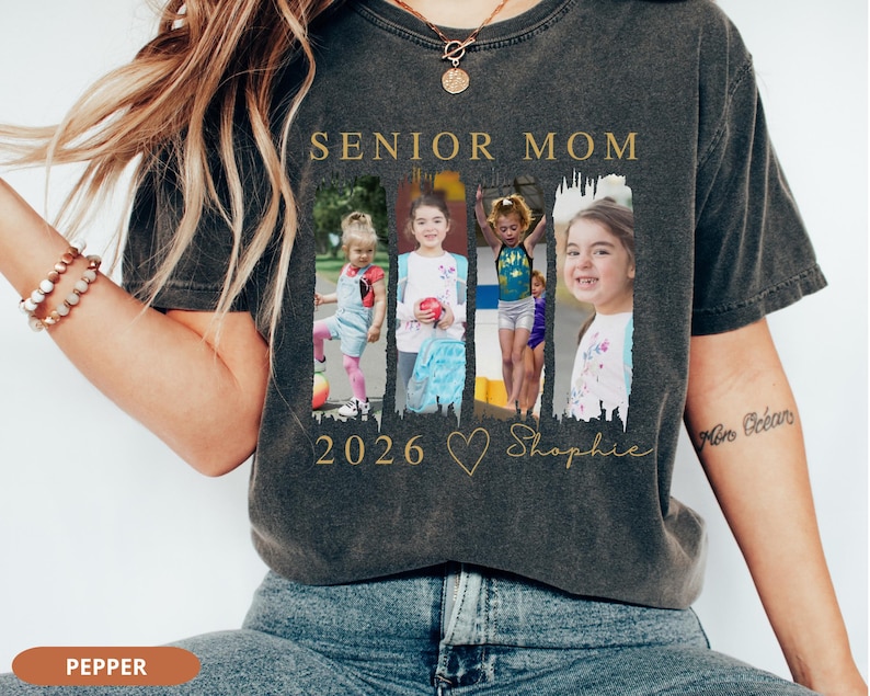 May include: Dark gray t-shirt with the words "SENIOR MOM" in gold lettering. The shirt features four framed photos of a child, the year "2026", a heart, and the name "Shophie" in gold script.