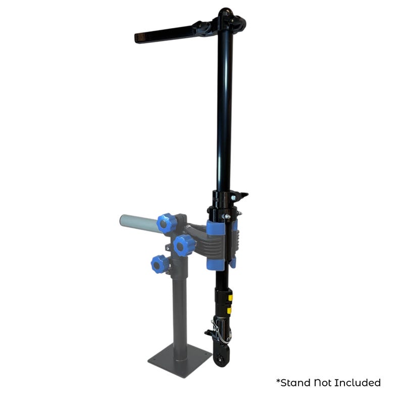 Pode incluir: Um suporte de repara&ccedil;&atilde;o de bicicletas preto com detalhes azuis e cinzentos. O suporte tem um bra&ccedil;o horizontal e um suporte vertical com grampos ajust&aacute;veis. A base &eacute; uma placa de metal quadrada. O texto "*Stand Not Included" est&aacute; na parte inferior.