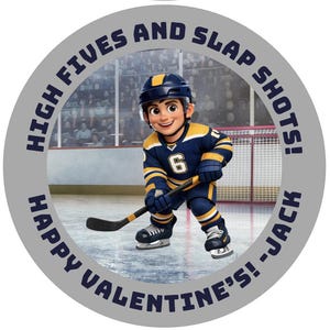 May include: A circular graphic with a cartoon hockey player in a blue and yellow uniform, holding a hockey stick. The text around the edge reads "HIGH FIVES AND SLAP SHOTS! HAPPY VALENTINE'S! -JACK". The background shows a hockey rink and spectators.