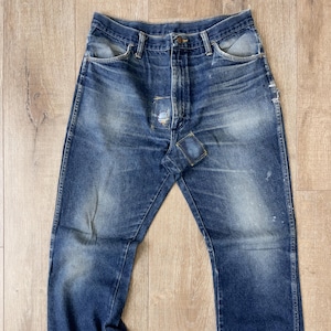 May include: A pair of blue denim jeans with distressed details and a patch on the right leg.