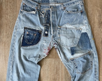 May include: Light blue denim jeans with multiple patches sewn on. The patches are made of different shades of blue denim and are sewn in a variety of shapes and sizes.