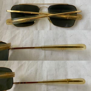Puede incluir: Gafas de sol de aviador con montura dorada y lentes verde oscuro. Las gafas tienen un dise&ntilde;o cl&aacute;sico con doble puente y patillas de pl&aacute;stico transparente. Las lentes son rectangulares y ligeramente curvadas.