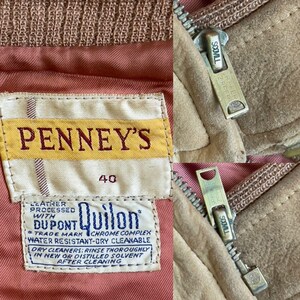 May include: Close-up of a vintage suede jacket with a zipper and a label that reads "PENNEY'S 40". The label also includes "DUPONT Quilon" and cleaning instructions. The jacket has a tan exterior and a pink lining.