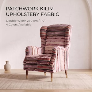 May include: A wingback armchair upholstered in a patchwork kilim fabric featuring horizontal stripes in shades of pink, red, brown, and cream. The chair has wooden legs with gold-toned caps. Text reads: PATCHWORK KILIM UPHOLSTERY FABRIC, Double Width 110 inches.