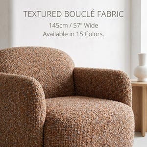 Może przedstawiać: Fotel tapicerowany teksturowaną brązową tkaniną typu bouclé. Tekst na obrazie: TEXTURED BOUCLÉ FABRIC, 145cm / 57" Wide, Available in 15 Colors. Fotel posiada zaokrąglone oparcie oraz zintegrowane podłokietniki o gęstej, wypukłej strukturze powierzchni.