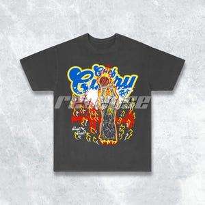 May include: Black t-shirt featuring a graphic of a basketball player engulfed in flames, with the text "Chef Curry" in blue and yellow lettering. The text "Night Night" is also visible on the shirt.