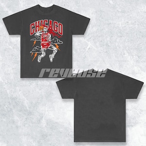 May include: Black t-shirt featuring a graphic print of a skeleton playing basketball. The graphic includes the text "CHICAGO" and lightning bolts.