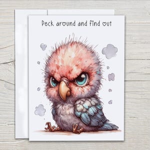 May include: Greeting card featuring a watercolor illustration of an angry-looking bird with a pink head, blue eyes, and blue and gray feathers. The text "Peck around and find out" is at the top. The card is on a white background.