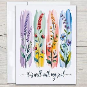 May include: Greeting card featuring watercolor floral designs in vertical brushstrokes of purple, green, peach, and blue. Each stroke showcases a different flower type. The phrase "it is well with my soul" is written in script at the bottom.