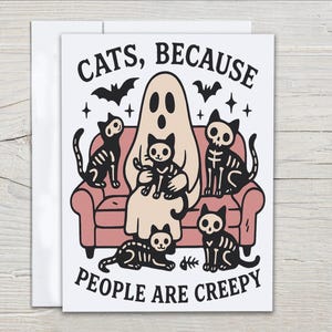 May include: A Halloween-themed greeting card featuring a ghost and skeleton cats on a pink couch. The text reads "CATS, BECAUSE PEOPLE ARE CREEPY" with bats and stars. The illustration is in black, white, and beige.