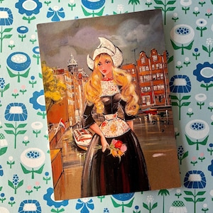Postal vintage sin usar de una chica holandesa con un disfraz de tulipanes en los canales de Holanda, años 70
