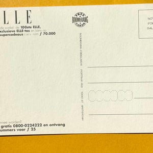 May include: White postcard with the word "ELLE" at the top left. The postcard has text in Dutch, a "BOOMERANG" logo, and a "NOT FOR SALE" stamp. The postcard is on a yellow background.