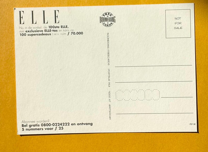 May include: White postcard with the word "ELLE" at the top left. The postcard has text in Dutch, a "BOOMERANG" logo, and a "NOT FOR SALE" stamp. The postcard is on a yellow background.