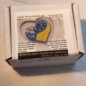 May include: A blue and yellow beaded heart with a floral design. The heart is 50x50mm and is labeled "Ukrainian heart/ Українське серденько".