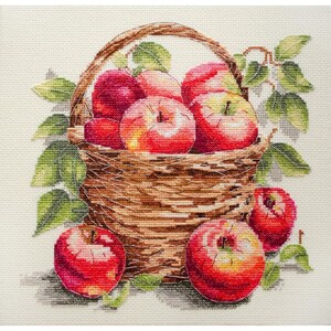 May include: A woven basket filled with red apples. The basket is sitting on a white background with green leaves.