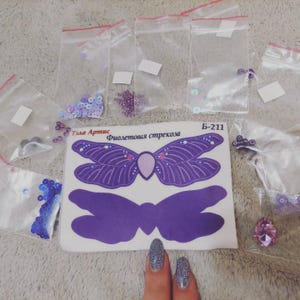 May include: A purple butterfly craft kit with a purple butterfly template, purple sequins, and clear plastic bags filled with assorted sequins. The kit is labeled "Фиолетовая стрекоза" which translates to "Purple Dragonfly".