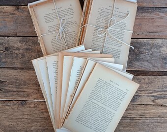 Puede incluir: Una pila de libros de bolsillo vintage atados con cuerda. Los libros son de varios tonos crema y tostado. Los libros están sobre una superficie de madera.