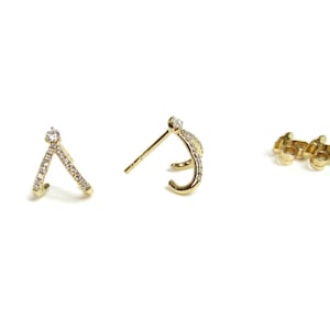 May include: A pair of gold earrings with a V-shaped design and small diamonds. The earrings are shown with a close-up view of the front and back.