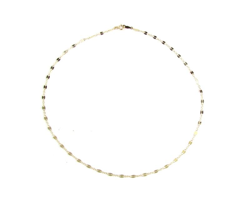 May include: Delicate gold-colored necklace with a repeating oval link design. The necklace is displayed on a white background. The chain is thin and the clasp is visible. This necklace is a piece of jewelry.