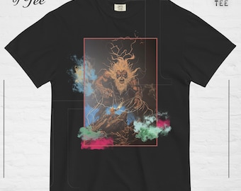 May include: A black short-sleeve t-shirt featuring a graphic print of a large, wild-haired creature standing over a smaller figure on a rocky terrain. The design is framed by a thin red rectangle and accented with colorful smoke clouds.