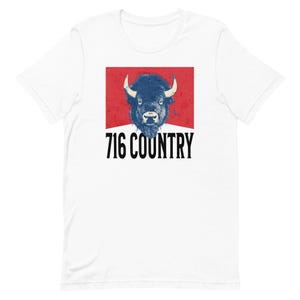 Op de afbeelding: Wit T-shirt met een rode rechthoek met een blauwe bizonskop en de tekst "716 COUNTRY" in zwart.