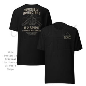 May include: Black t-shirts with a graphic design featuring a B-2 Spirit stealth bomber. The design includes the text "INVISIBLE INVINCIBLE" and "B-2 SPIRIT STRATEGIC AIR COMMAND". The shirt also has the text "SPIRIT" and coordinates.