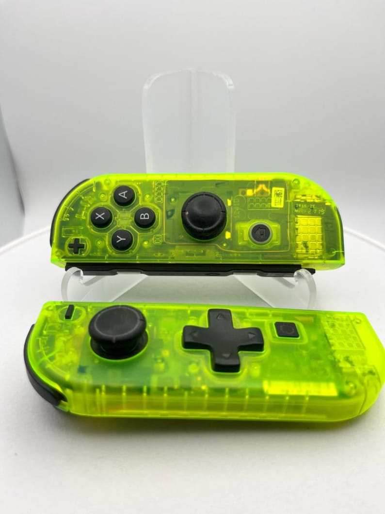 May include: A pair of neon green Nintendo Switch Joy-Con controllers. The top controller has the standard buttons, while the bottom controller has a larger D-pad.
