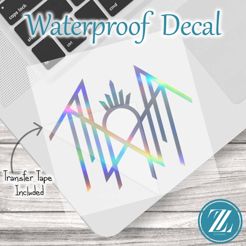 May include: A holographic waterproof decal featuring a stylized geometric design with sharp lines and a central sunburst element. The decal is presented on a clear backing sheet with an arrow pointing to the text Transfer Tape Included.