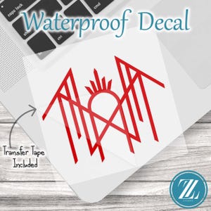 May include: A red waterproof decal featuring a geometric, angular line art design with a central sunburst motif. The decal is presented on a clear backing sheet with the text Waterproof Decal at the top and Transfer Tape Included with an arrow.