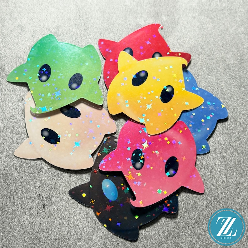 May include: A collection of colorful, star-shaped stickers with a cartoonish design. The stickers are in various colors, including green, red, yellow, blue, pink, and black, and feature a holographic, glittery finish. Each sticker has two black oval eyes.