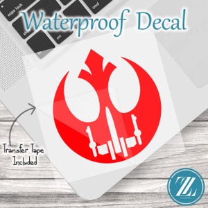 May include: A red waterproof decal featuring a stylised Rebel Alliance symbol combined with an X-wing starfighter silhouette. The decal is on a clear backing with transfer tape included. The text Waterproof Decal and Transfer Tape Included are visible.