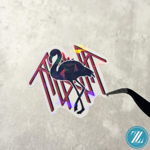 May include: Holographic sticker featuring a stylized flamingo with geometric patterns. The flamingo is black with a colorful, iridescent effect. The sticker has a red and white striped background and is held by tweezers.