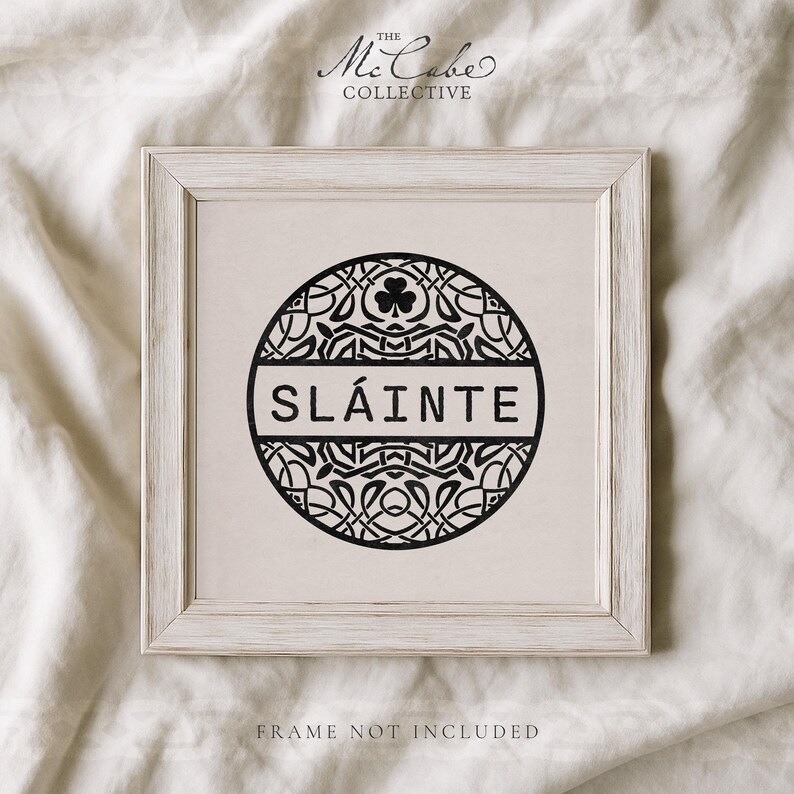May include: A square print featuring a black circular design with intricate Celtic knotwork and a central shamrock icon. The word SL&Aacute;INTE is printed in a bold, sans-serif font across the middle. The text THE MCCABE COLLECTIVE appears above.