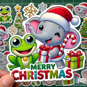 Puede incluir: Una pegatina con temática navideña que presenta un elefante gris con un gorro de Papá Noel rojo y sosteniendo un bastón de caramelo. El elefante está de pie junto a una rana verde y una caja de regalo roja y blanca. La pegatina también incluye el texto "Feliz Navidad".