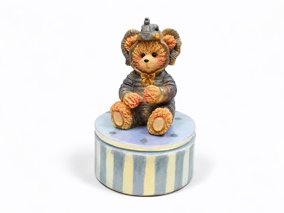 A teddy bear sculpted in an elephant costume, cast in epoxy resin as a tiny keepsake box — absurdly specific and weirdly delightful.