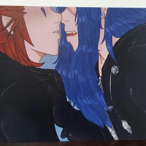 May include: A close-up of a drawing of two people with red and blue hair. The person with red hair is on the left and the person with blue hair is on the right. They are both wearing black clothing. The person with red hair has a purple eye and the person with blue hair has a blue eye.